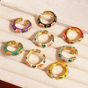 Floral enamel gold plated ear cuffs in various colors arranged in a jewelry box