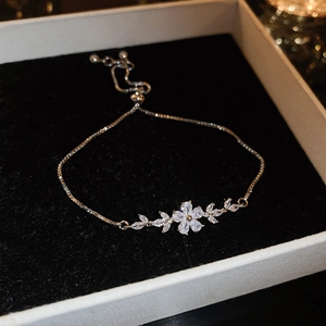 Detailed view of adjustable zircon flower bracelet with sparkling stones on black velvet