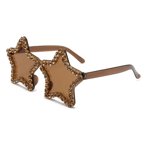 Macro detail of star-shaped sunglasses with amber rhinestones and tinted lenses