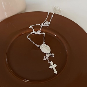 Macro view of 925 silver rosary necklace with Virgin Mary medal and crucifix pendant