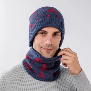 Close-up of dark blue knit hat and neck warmer with festive red cedar tree patterns