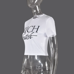 Dettaglio del crop top bianco con stampa a lettere RICH nere e tessuto jersey elastico
