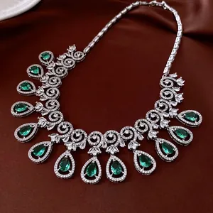 Luxury silver necklace with waterdrop green zircon pendants on elegant silk backdrop