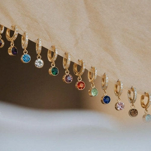 Pendientes de piedra de nacimiento bañados en oro con circonitas de colores sobre tela