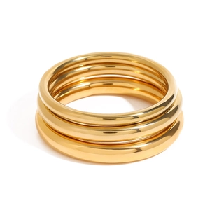 Detailed view of three polished 18k gold plated stainless steel bangles set