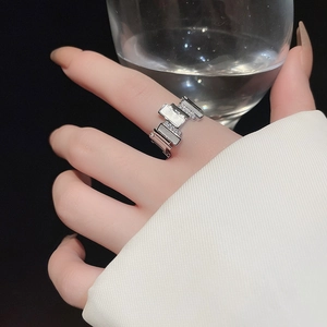 Detail of silver geometric zircon ring worn on finger with elegant metallic finish