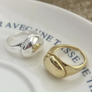 Detail of vintage 925 silver open rings in gold and silver with textured oval rim