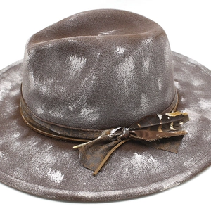 Detail of brown wool fedora with vintage white spray finish and feather leather band