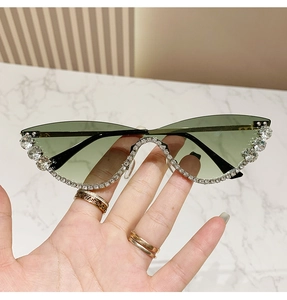 Detail of green cat-eye sunglasses featuring luxury silver rhinestones on the frame