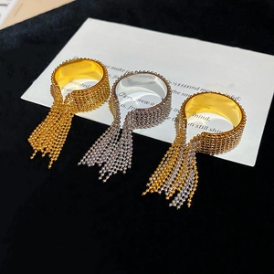 Macro shot of gold and silver beaded fringe rings on a black velvet background
