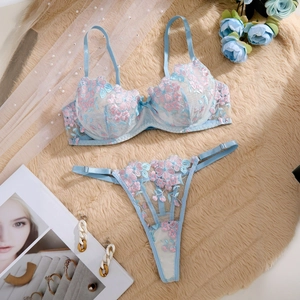 Detailed flat lay of light blue lace lingerie set with floral embroidery on faux fur
