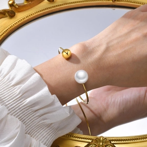 Minimalist 18K gold stainless steel open bangle with pearl and bead on wrist