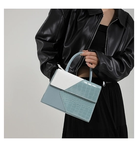 Détail du sac à main bleu clair et blanc avec textures cuir crocodile et cuir de litchi