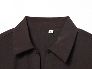 Detail of shirt collar with size L label and brown fabric texture on midi dress