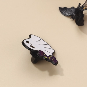 Macro view of cute white ghost enamel pin with purple polka dot border and black bat