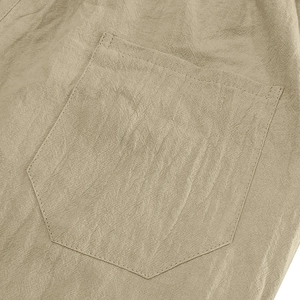 Detail view of linen shorts showing a reinforced back pocket with double-needle stitching
