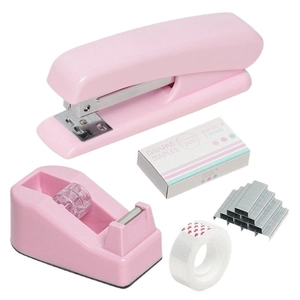 Set di cancelleria rosa con cucitrice dispenser di nastro e punti su sfondo bianco