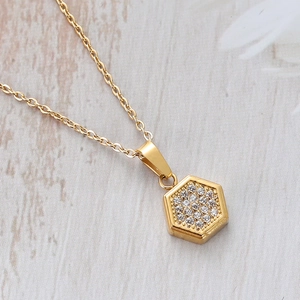 Macro shot of gold geometric hexagonal pendant with pavé cubic zirconia on cable chain