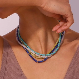 Close-up of four-layer bohemian beaded necklace with cylindrical blue and purple beads
