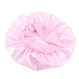 Detail of pink satin sleep bonnet featuring a wide elastic band and smooth texture