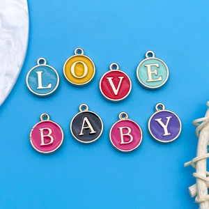 Macro shot of colorful round enamel letter charms spelling LOVE BABY for DIY jewelry
