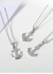 Detail of silver titanium steel anchor pendants with white cubic zirconia inlay details
