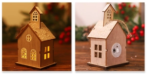Macro detail of wooden LED Christmas house ornament with snow roof and warm lighting