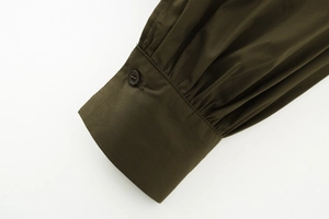 Detail of army green cotton poplin shirt showing pleated cuffs and button closure