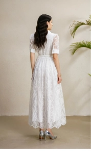 Détail de la robe longue en dentelle blanche avec broderie florale creuse au dos