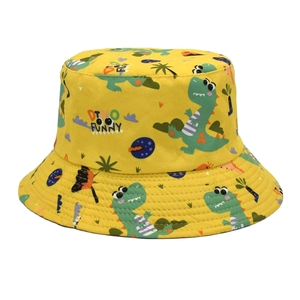 Close-up of yellow cotton bucket hat featuring cartoon dinosaur prints and DI NO FUNNY text