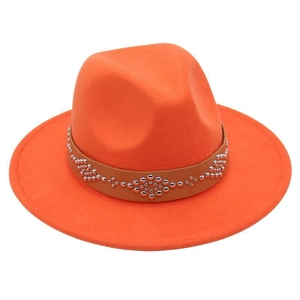 Close-up of orange wool fedora featuring a brown leather band with silver metal rivets