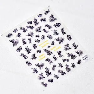Detailed macro view of retro floral nail stickers featuring purple and grey flower patterns