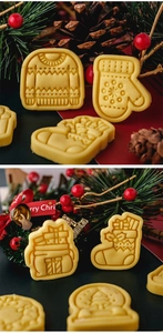 Christmas cookies with sweater, glove, and gift shapes on a festive pine cone background