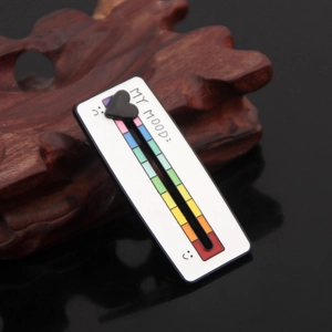 Close-up of sliding heart indicator on rainbow social battery mood enamel brooch