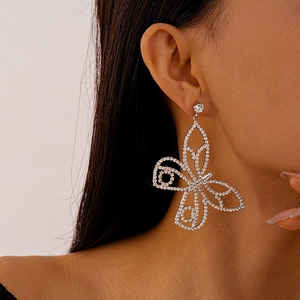 Macro shot of butterfly stud earring featuring silver hollow design and sparkling zircon stones