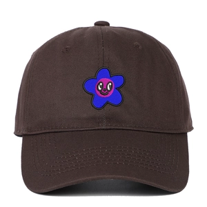 Détail de la broderie de fleur de dessin animé bleu sur une casquette marron