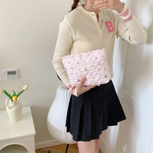Detail view of pink quilted travel cosmetic bag with cute bunny and heart patterns