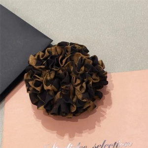 Detail of the layered leopard print scrunchie with voluminous pleated fabric ruffles