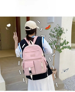Detail of pink canvas backpack featuring multiple pockets and durable buckle closures