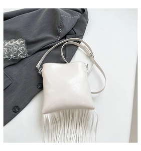 Detailed view of white faux leather crossbody bag with stylish long fringe tassels