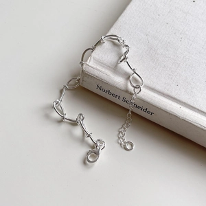 Handcrafted S925 sterling silver woven twisted chain bracelet with lobster clasp on a book
