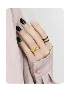 Detail of gothic style irregular wavy gold and black lava textured open rings on hand