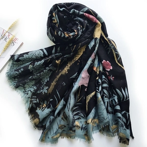 Black satin scarf with bird and flower print and elegant tassels on white background