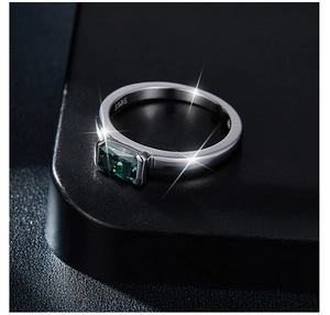 Macro detail of S925 silver ring featuring a radiant cut green moissanite gemstone