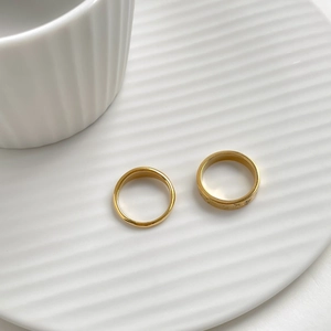 Detail of star and moon gold rings set with zircon on white textured ceramic tray