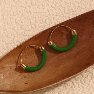 Detailed view of geometric emerald green hoop earrings in 18K gold plated stainless steel