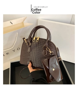 Detail of dark brown crocodile pattern shell bag with small matching purse and gold hardware