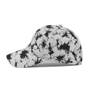 Side view of cotton baseball cap with unique black and white tie-dye splatter pattern