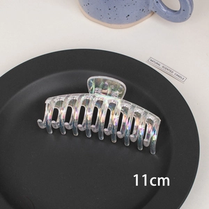 Detail view of 11cm iridescent transparent hair claw clip on a minimalist black base