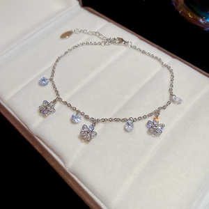 Détail d'une chaîne de cheville argentée avec papillons en zircon sur une boîte à bijoux